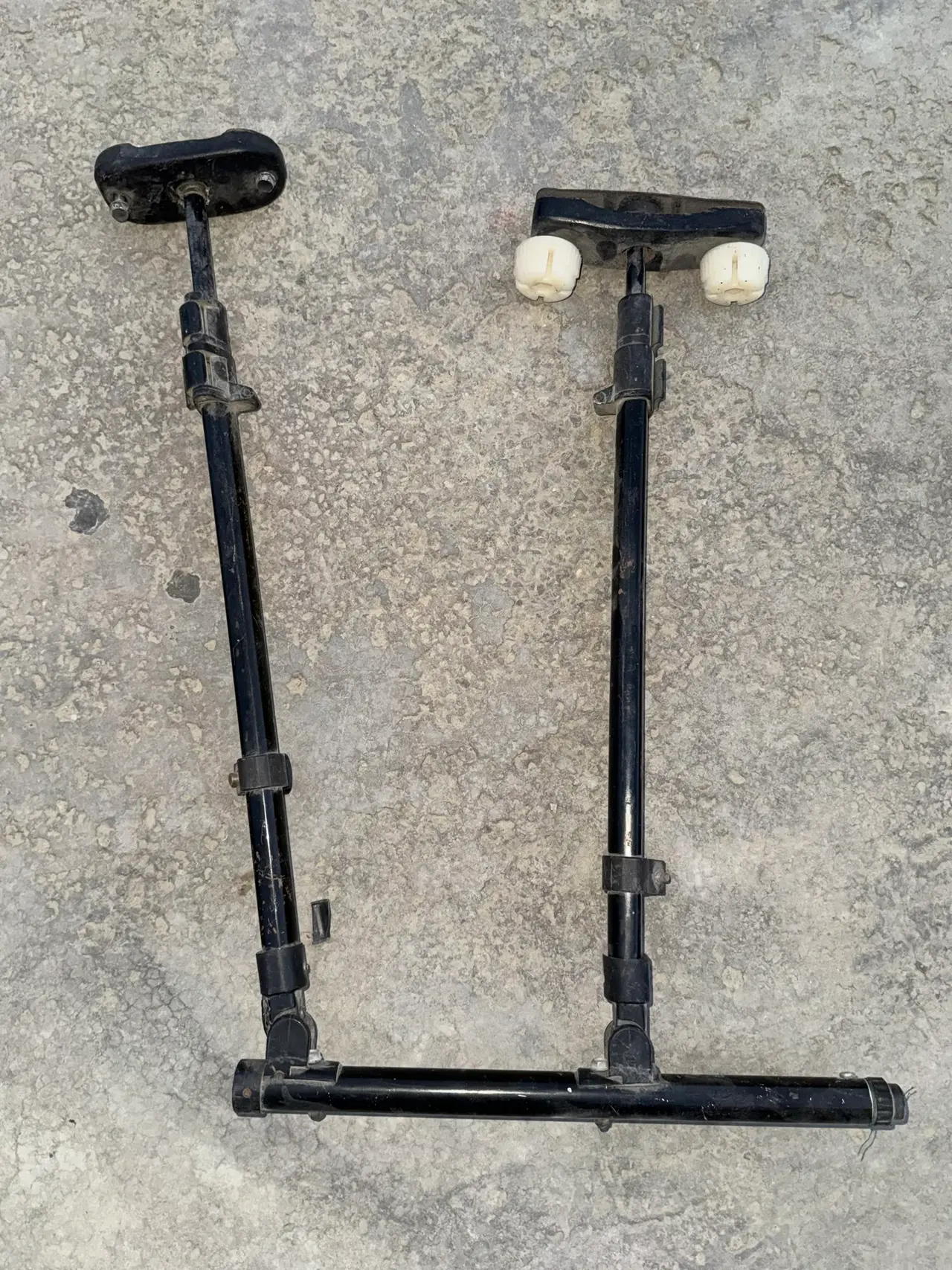 The 2016 hand control: two black tripod legs standing upright with flat pads on top, joined at the base by a cross tube.